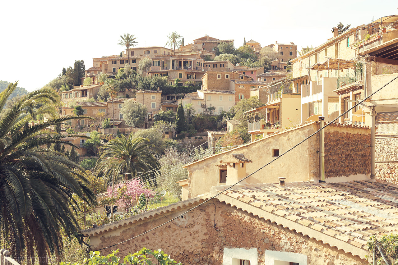 Foto von Lush greenery frames the terracotta rooftops of Deià, a peaceful village nestled in Mallorca's Serra de Tramuntana.