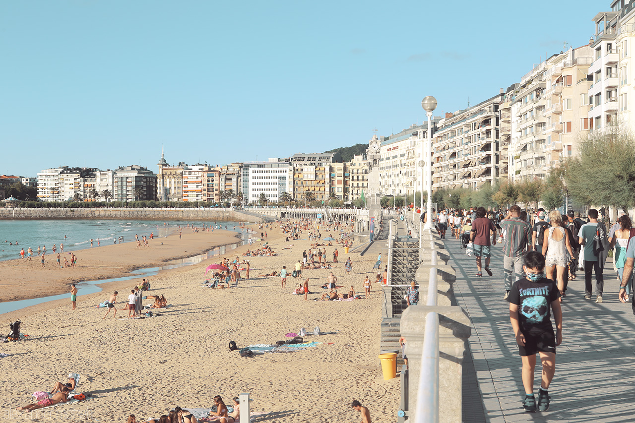 Foto von A serene day wanes on San Sebastián's La Concha beach, with strolling visitors and sun-kissed sands.