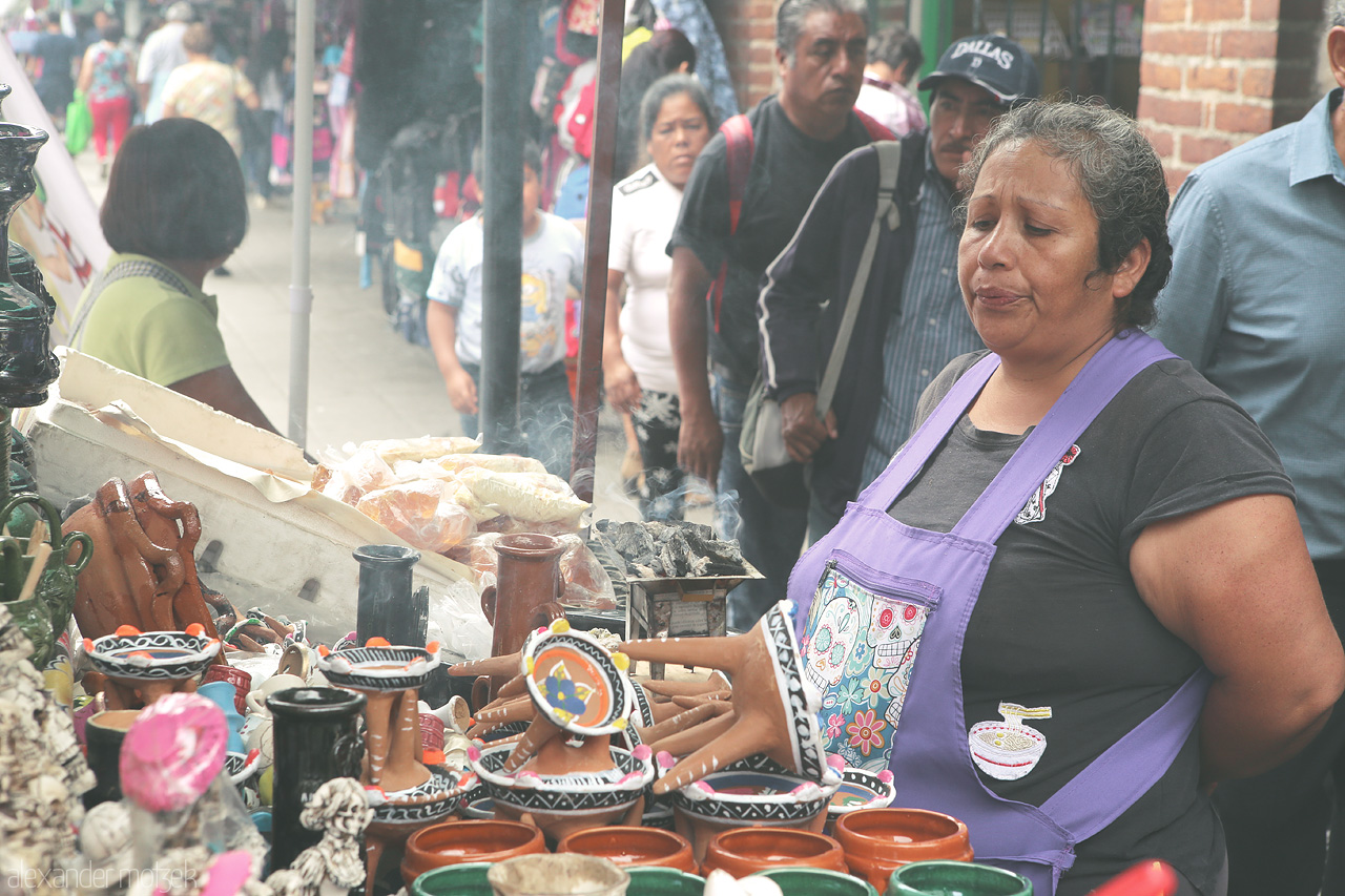 Oaxaca Vivencias Foto von A vendor in Oaxaca de Juárez presents her array of colorful pottery amidst a bustling street scene.