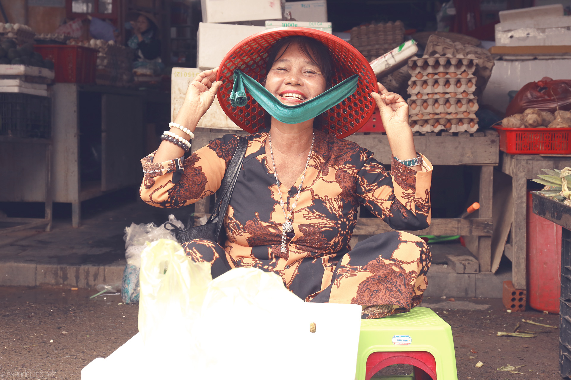 Foto von A vibrant smile lights up Hoi An's market, as a vendor in traditional attire shares a moment of pure Vietnamese joy and warmth.