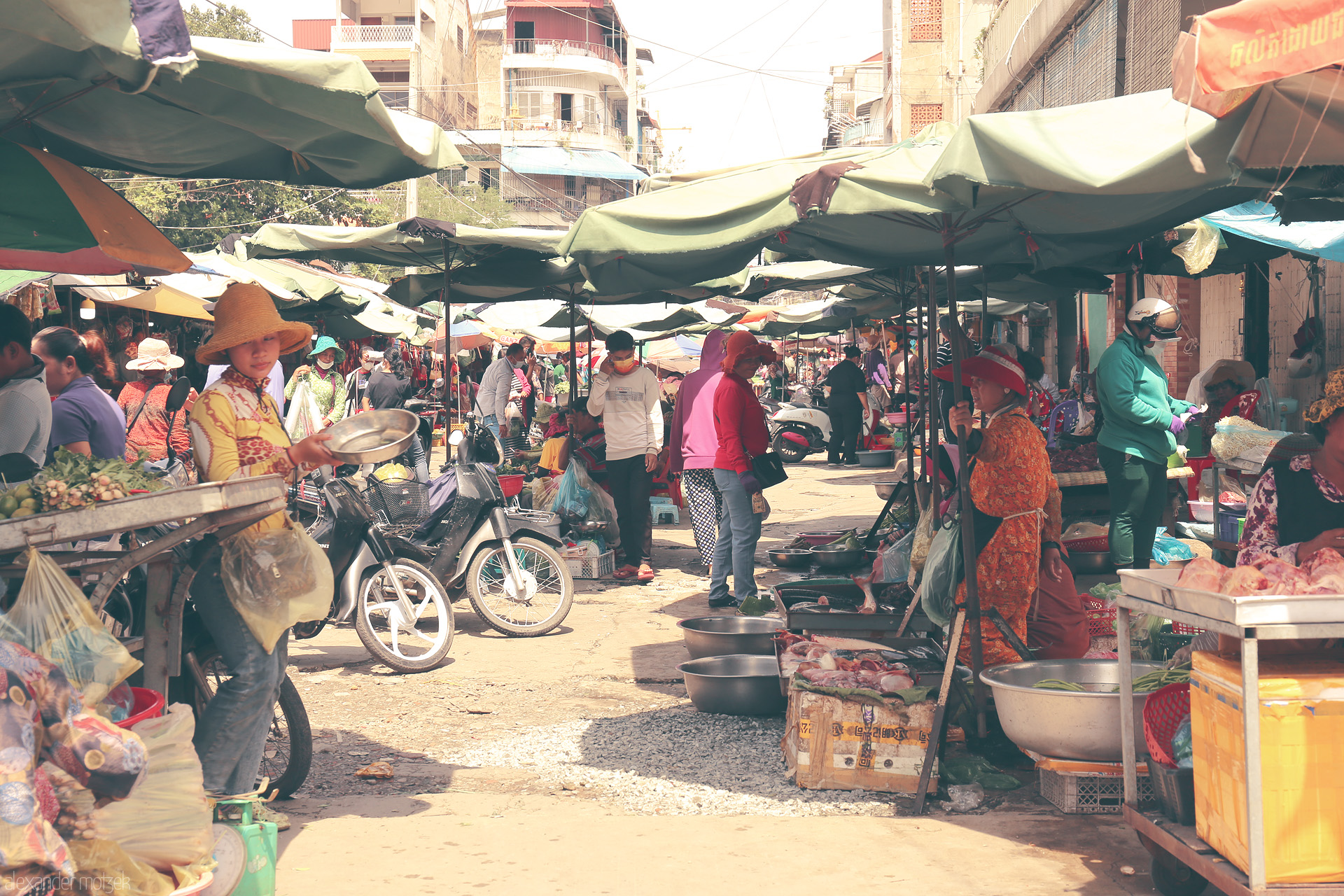 Foto von A vibrant street market in Phnom Penh, bustling with locals, colorful umbrellas, and fresh produce under the Cambodian sun.