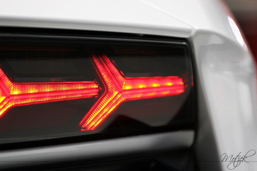 Foto von Close-up of a glowing red car taillight, showcasing urban life's pulse and style.