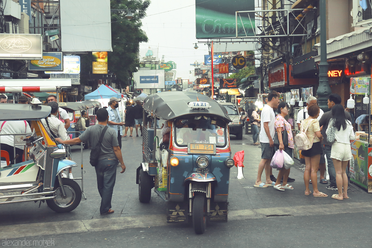 Foto von Experience the vibrant streets of Bowon Niwet, Bangkok, where tuk-tuks weave through lively markets and bustling crowds.