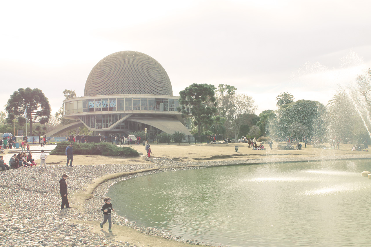 Foto von Astronomical wonders at Planetario Galileo Galilei, Buenos Aires, with tranquil waters and playful wanderers under a sunlit sky.