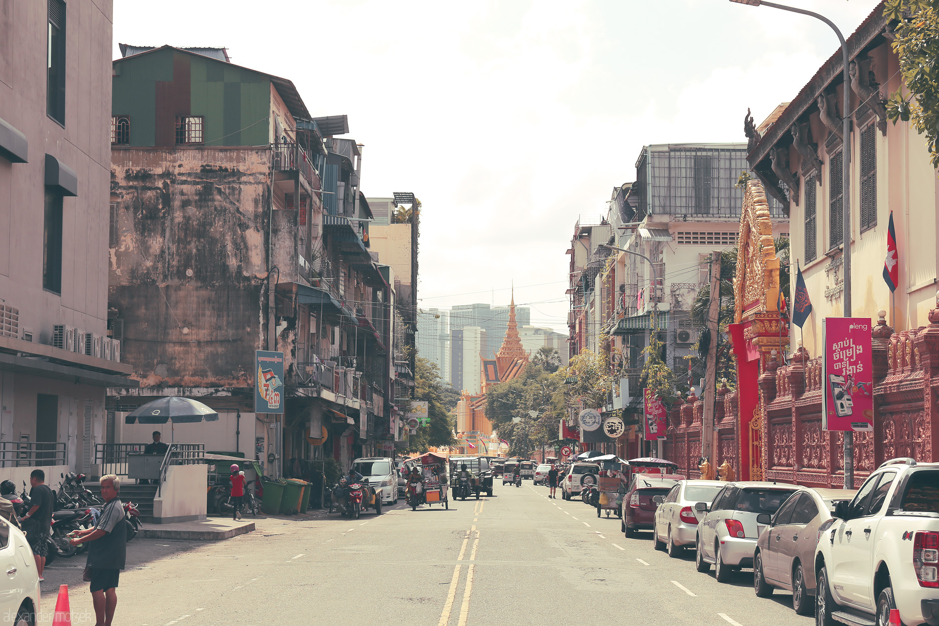 Foto von Bustling Phnom Penh street life leads to a golden wat, where city rhythm and Khmer tradition blend under tropical light.