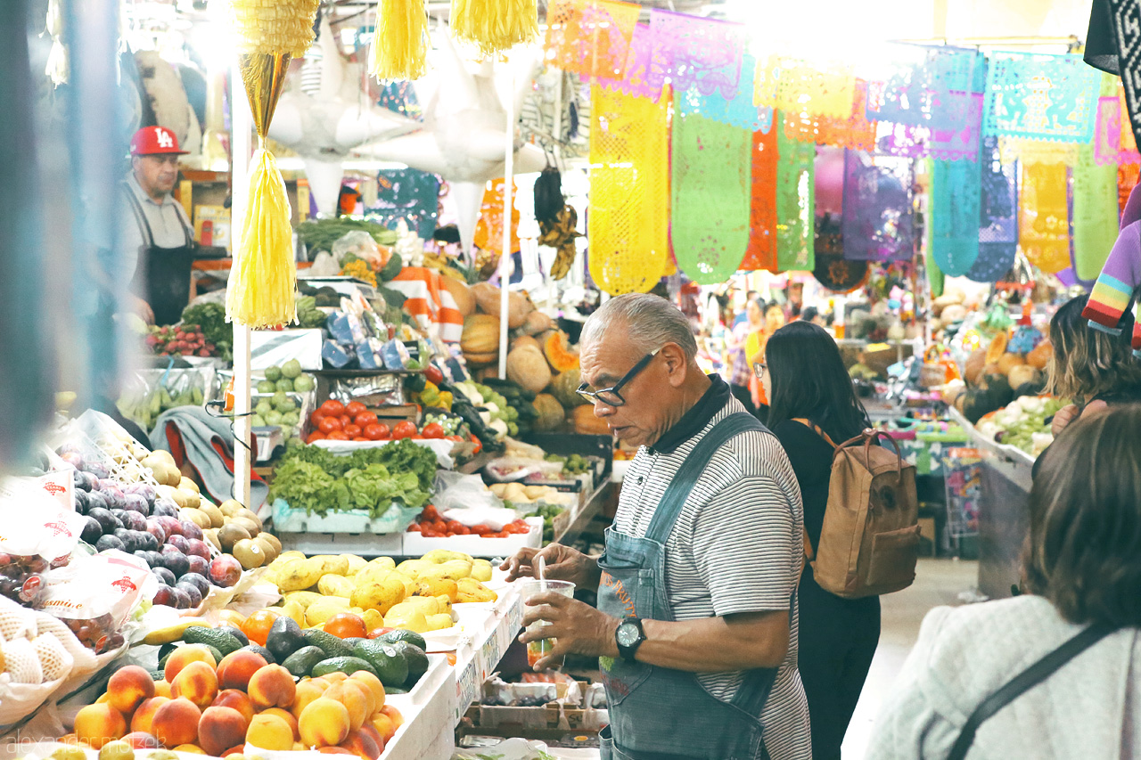 Coyoacán Colores Foto von Bustling market life amidst vibrant papel picado in the heart of Coyoacán, Mexico City.