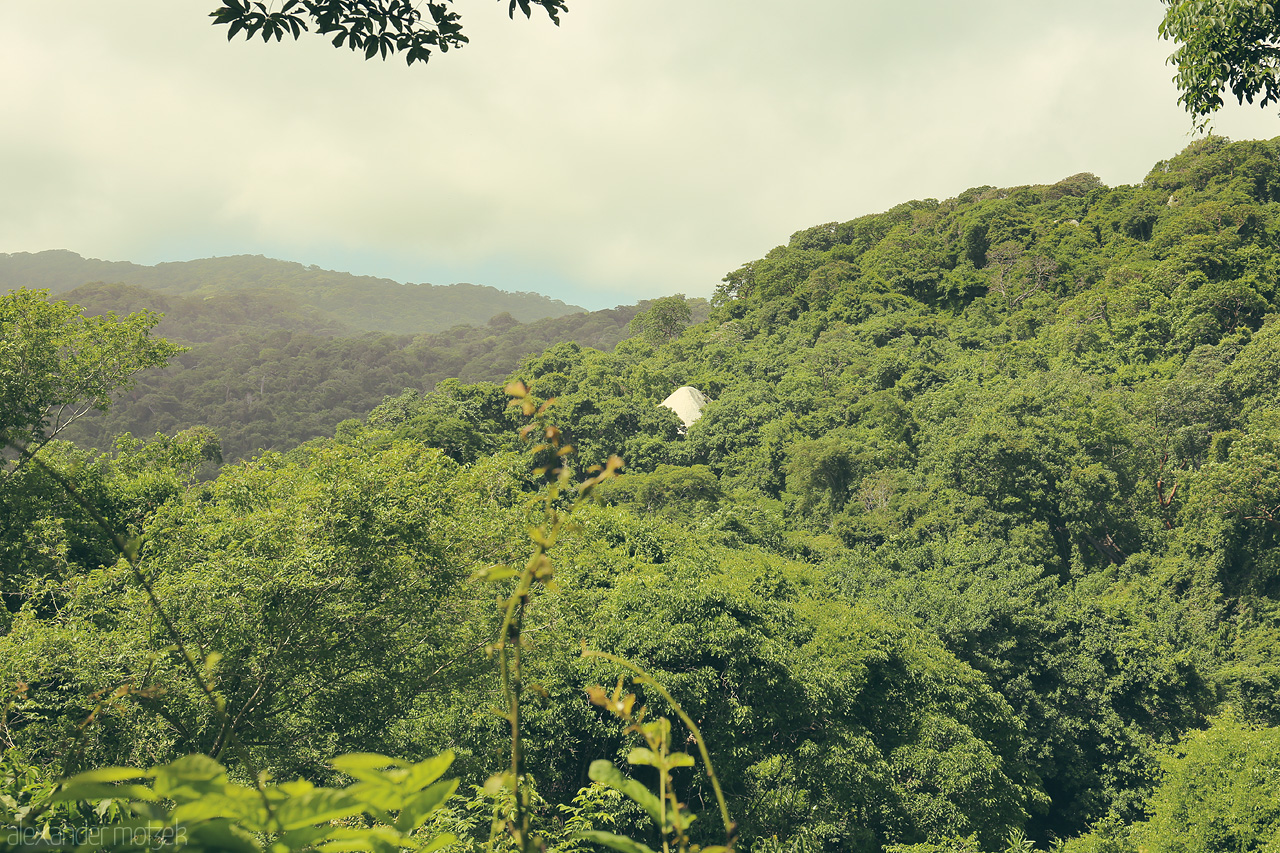 Foto von A canopy of lush green jungle blankets the hills of Tayrona, Santa Marta, where a tent-like white rock peeks through, inviting an eco-immersion adventure.
