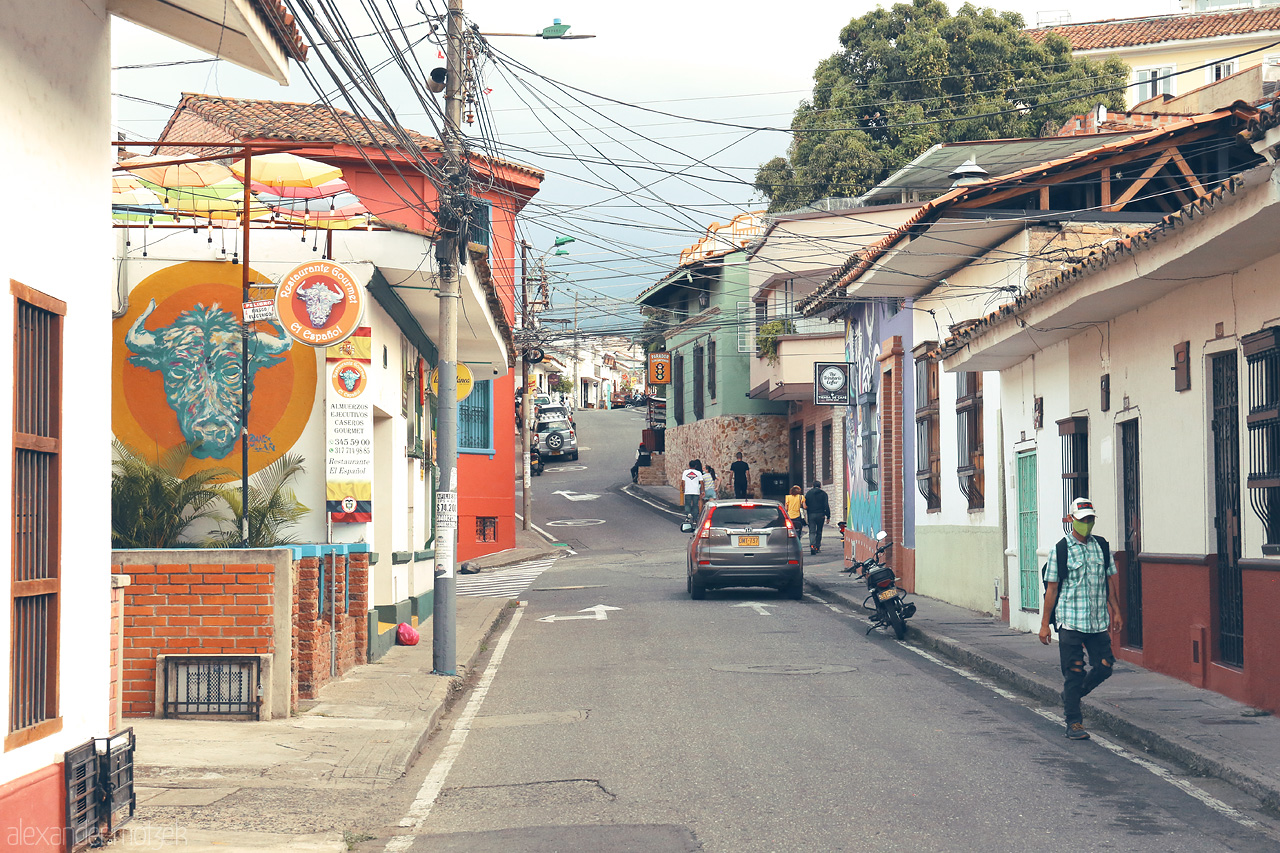 Foto von A lively street scene in Comuna 3, Cali, Colombia with colorful murals, local residents, and charming architecture.