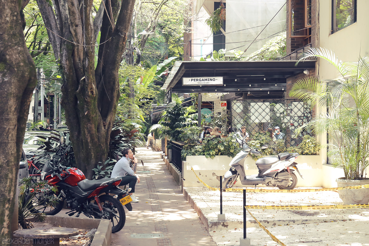 Foto von A serene café scene under lush greenery in the heart of Comuna 14 - El Poblado, Medellín, Colombia.