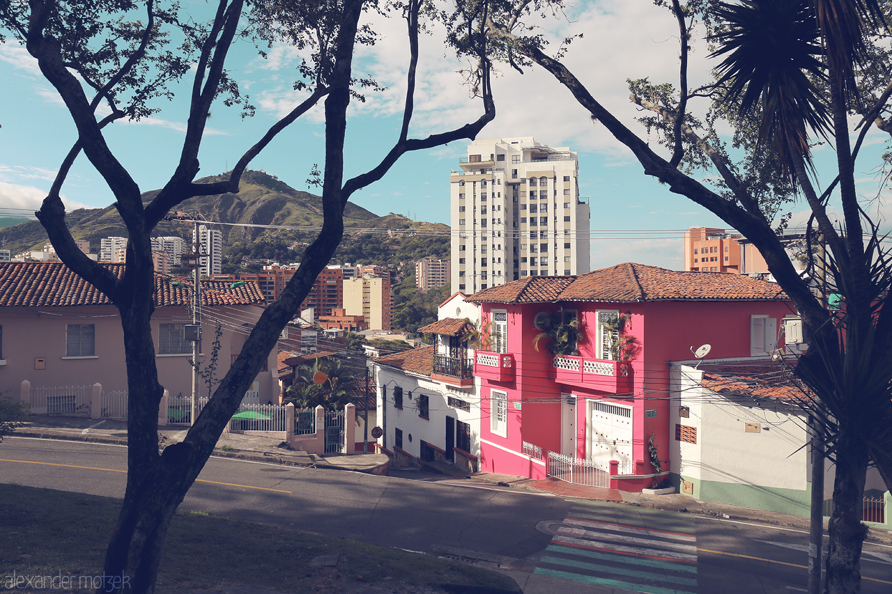 Foto von A splash of color and life in Comuna 3, Cali, Colombia with vibrant houses and serene views under a clear sky.