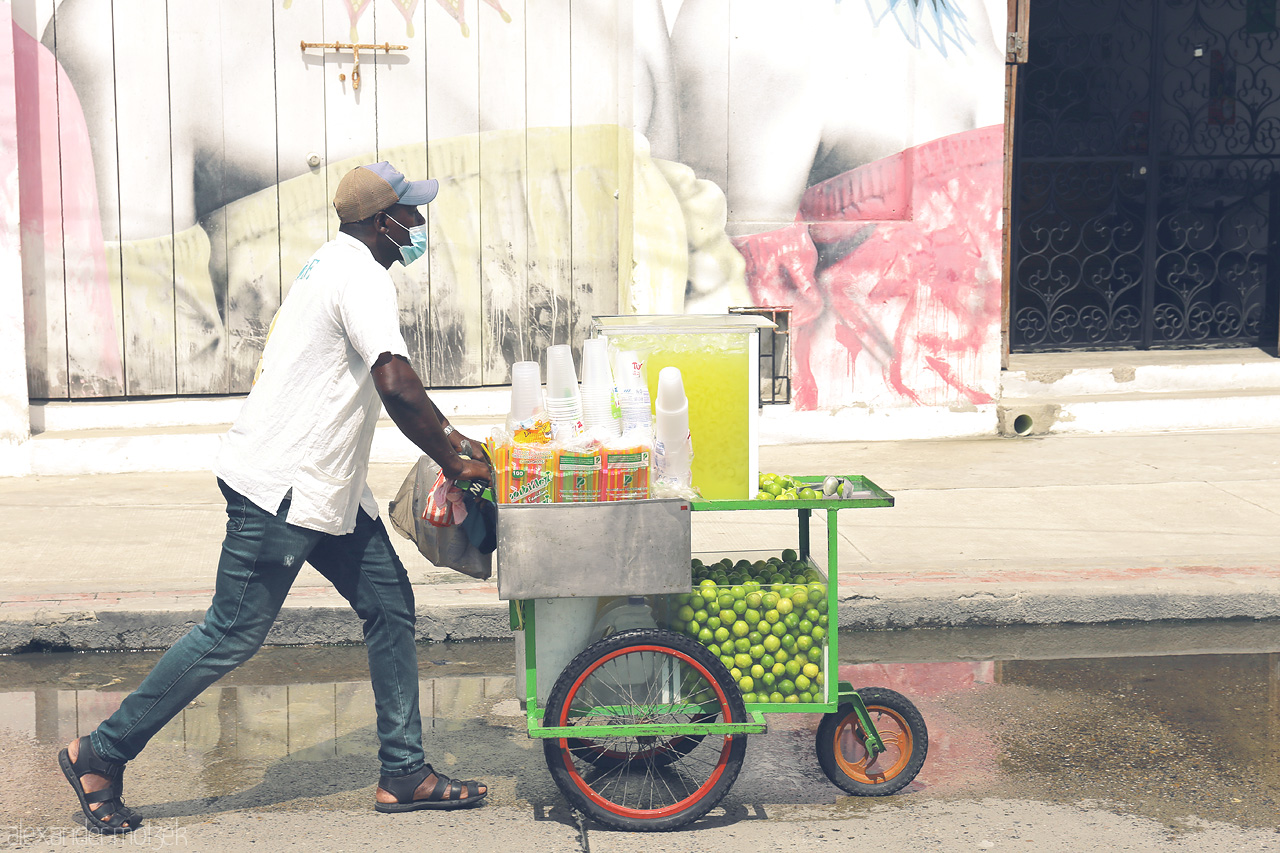 Foto von A vendor sells refreshing lime juices from a vibrant cart in the lively streets of Cartagena, Colombia. Bright, colorful, and full of local charm.