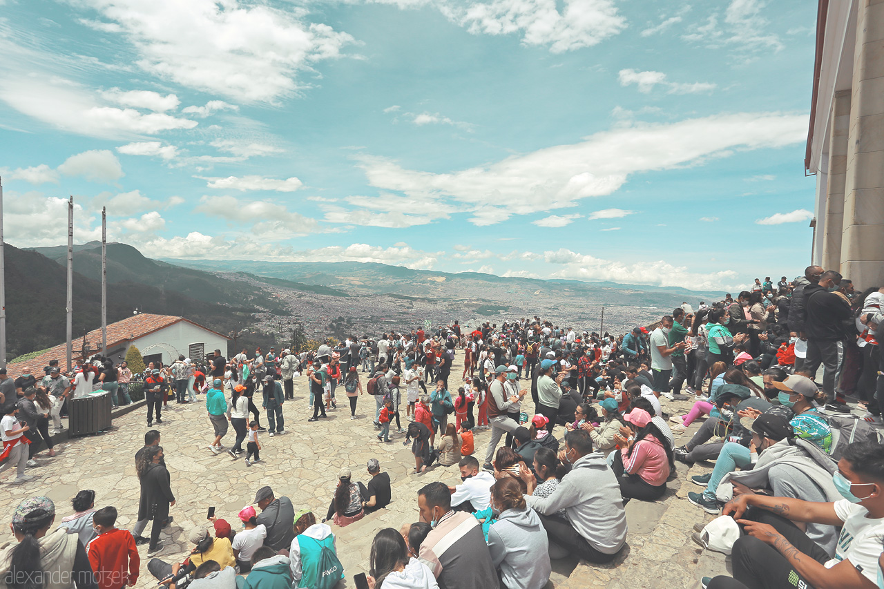 Foto von A vibrant crowd gathers on the scenic heights of Monserrate in Santa Fé, Bogota, Colombia, under an expansive blue sky.