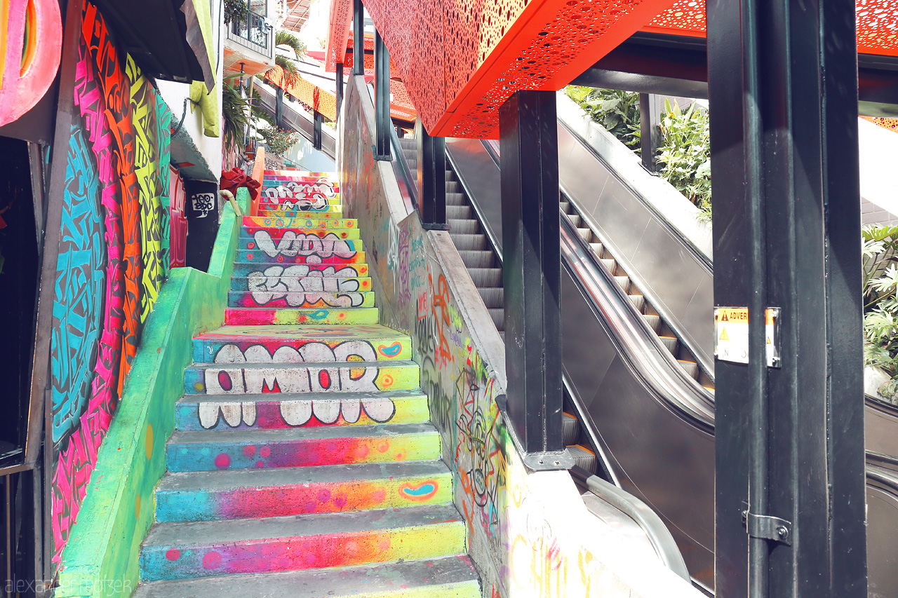 Foto von Brightly painted stairs adorned with graffiti next to an urban escalator in Comuna 13, Medellín, showcasing the neighborhood's vibrant spirit.