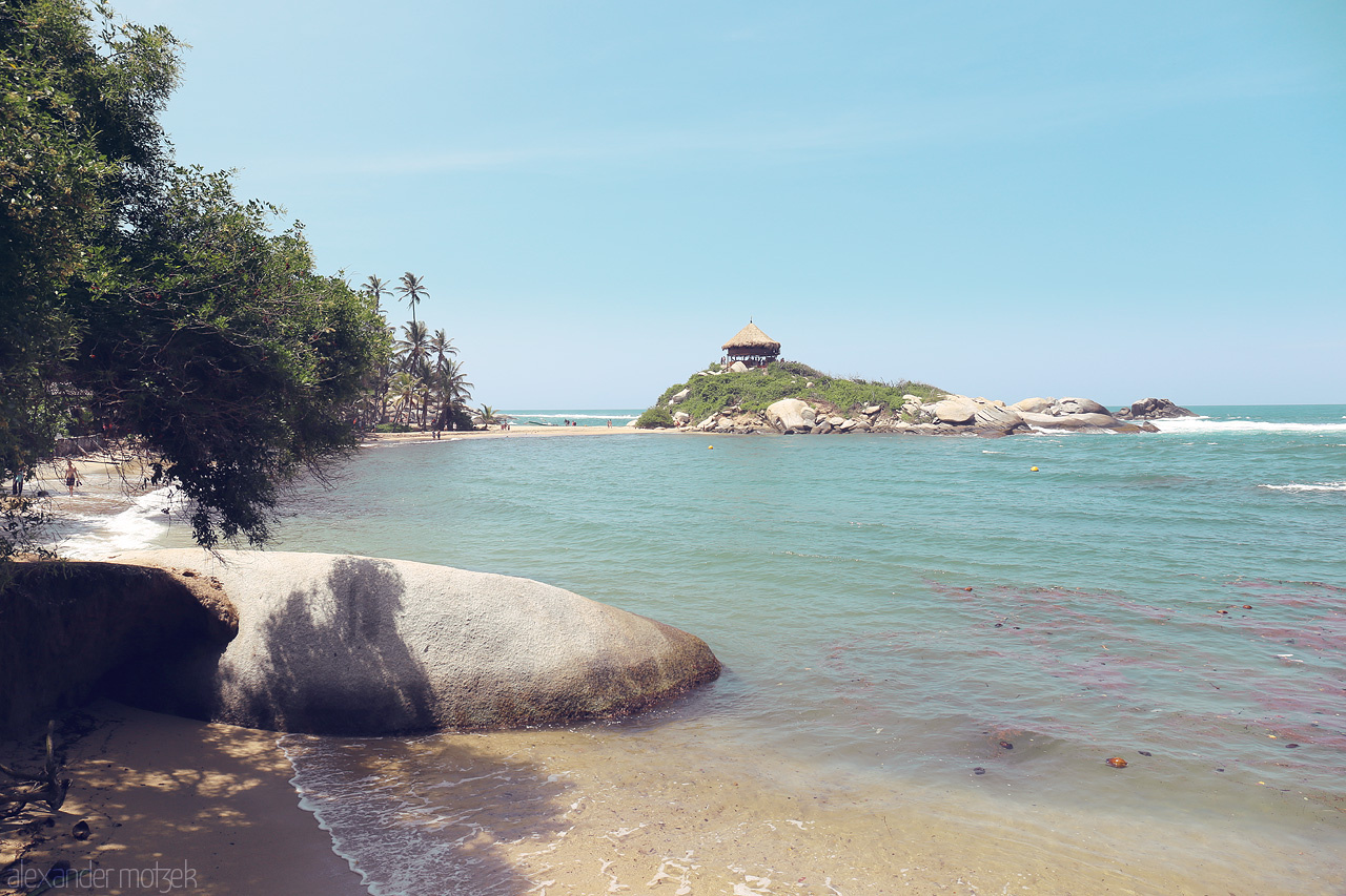 Foto von Discover the tranquil beauty of Tayrona, Santa Marta, Colombia – secluded beach, lush foliage, and a rustic hut perched majestically above the waves.