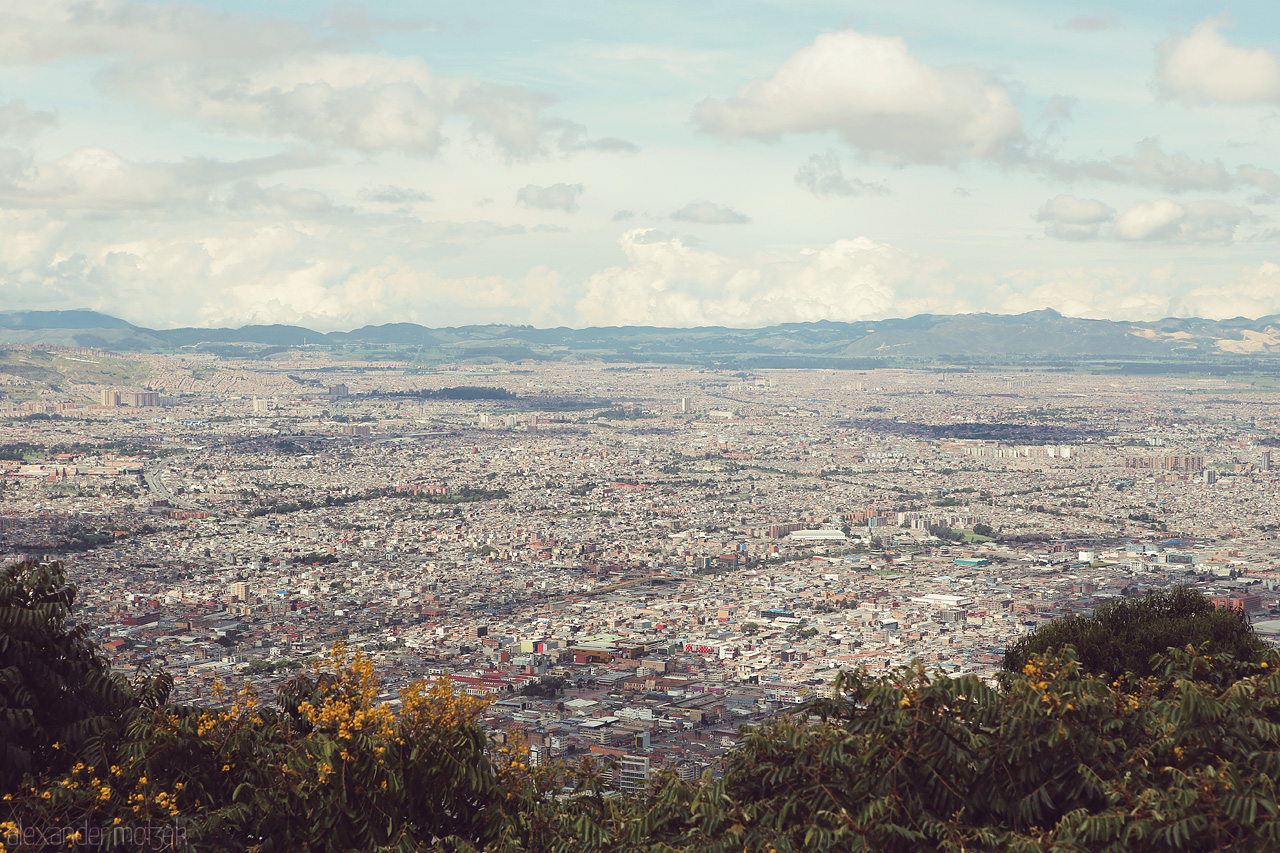 Foto von Gaze over the sprawling cityscape of Bogotá from Santa Fé. Majestic mountains frame the horizon under a vast sky, offering a glimpse into Colombia's beauty.