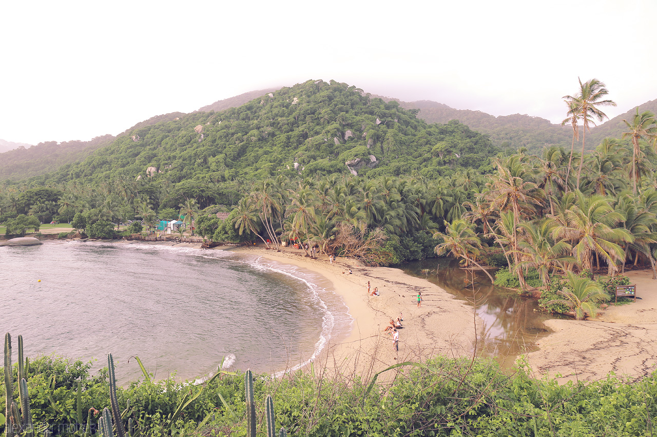 Foto von Lush green mountains blend into serene, golden sands of Tayrona, Santa Marta, Colombia, where tranquility and nature converge.