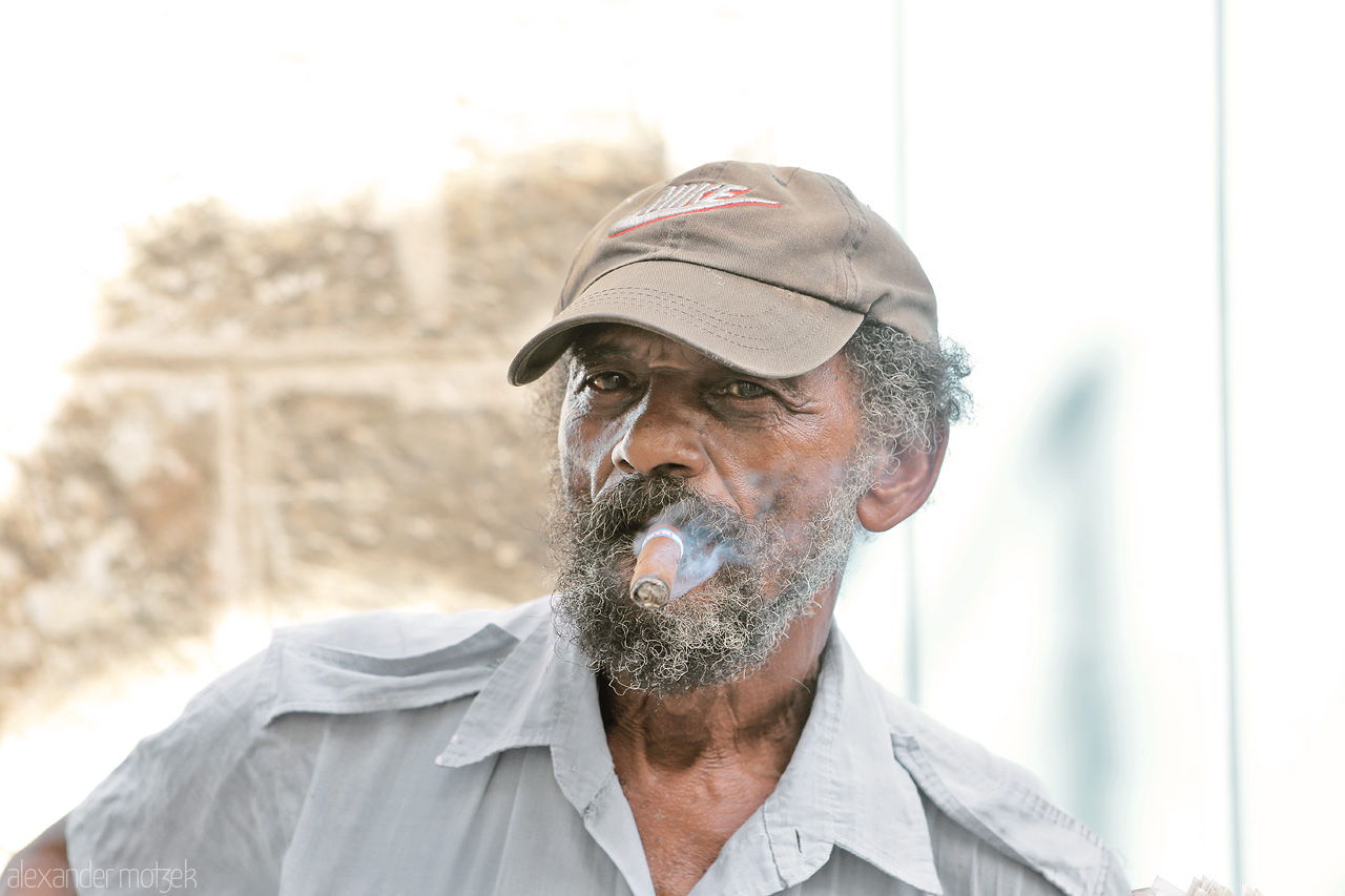 Foto von Ein Zeitungsverkäufer raucht eine Zigarre in Havana auf Kuba