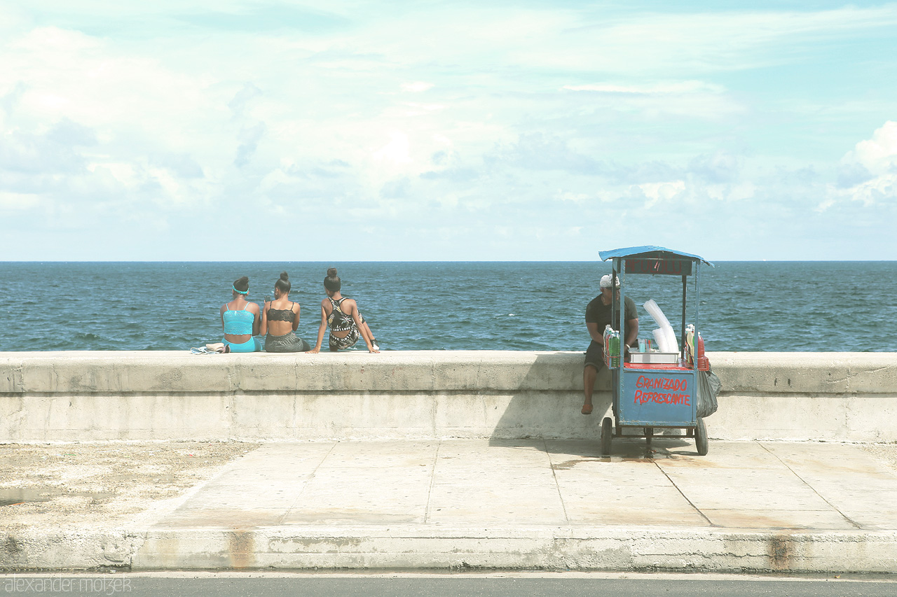 Foto von Frauen sitzen auf der Ufermauer entlang des Malecón in Havana