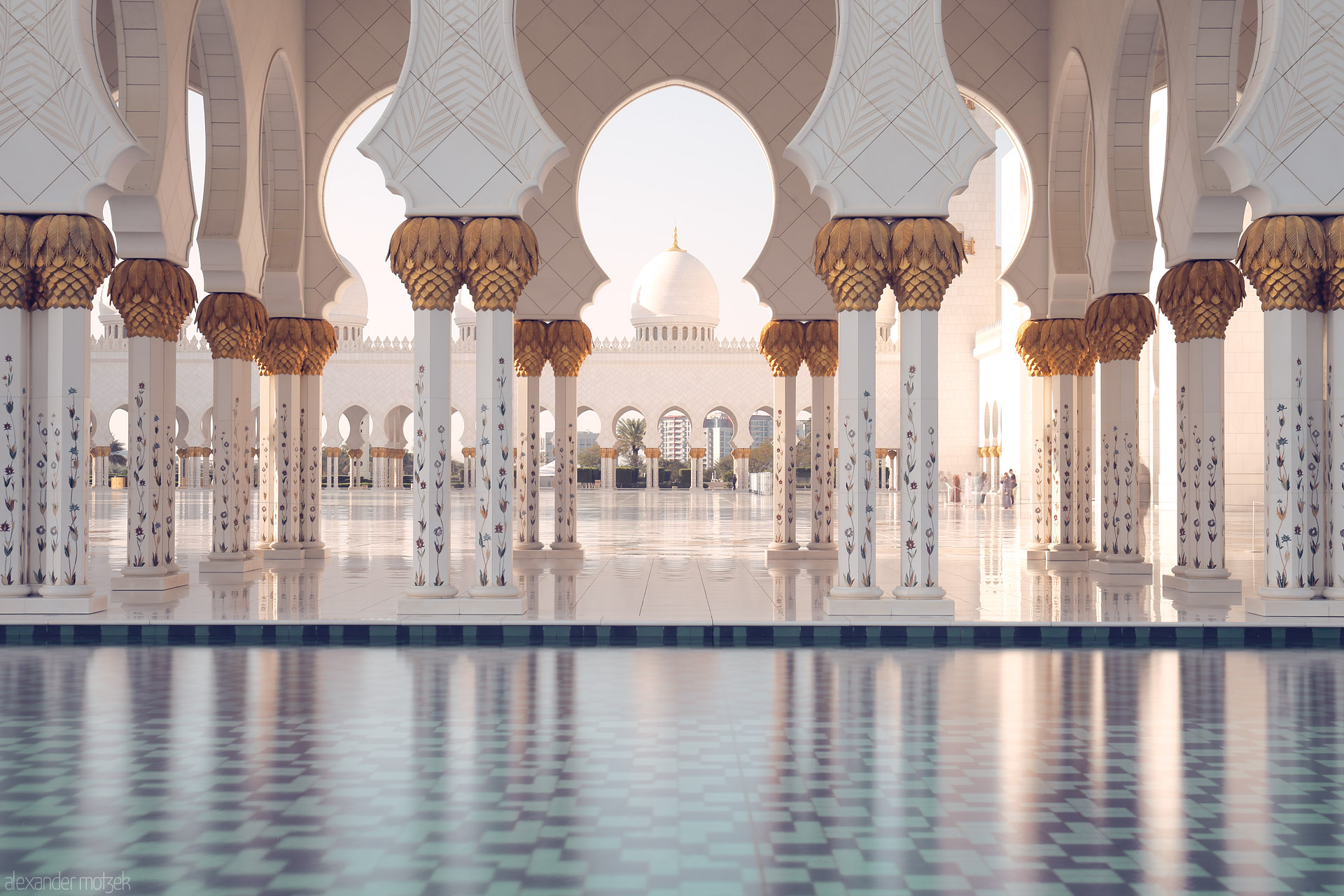 Foto von Golden palm columns and reflected mosaics at Sheikh Zayed Grand Mosque, Al Rawdah, Abu Dhabi, bathe in the morning light.