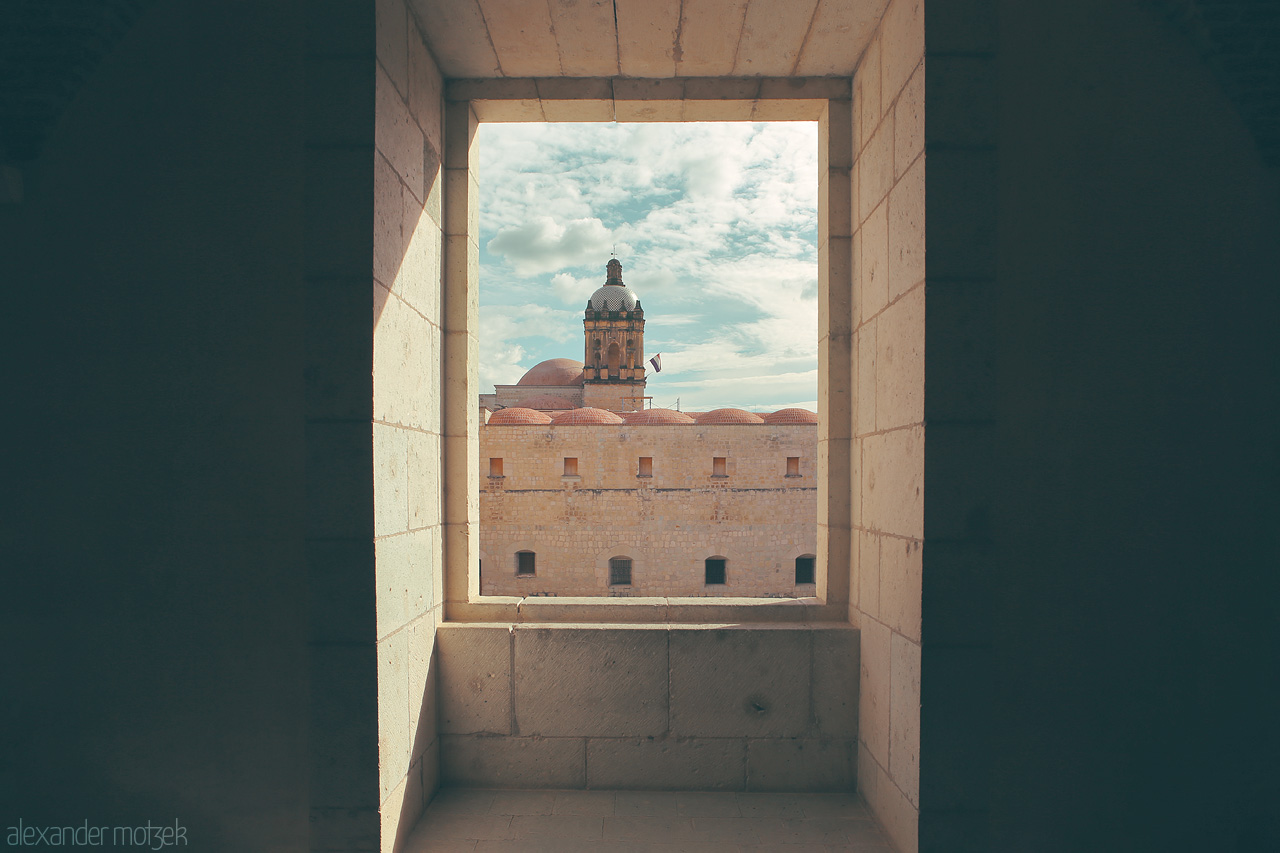 Oaxaca Ventana Foto von Framed vista of Oaxaca's historic architecture seen through a stone window, capturing the essence of Mexico.