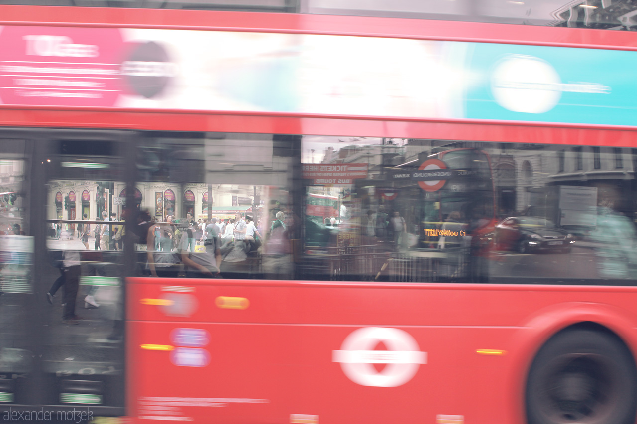 Foto von A dynamic capture of a classic London red bus in motion, blurring past iconic city streets.