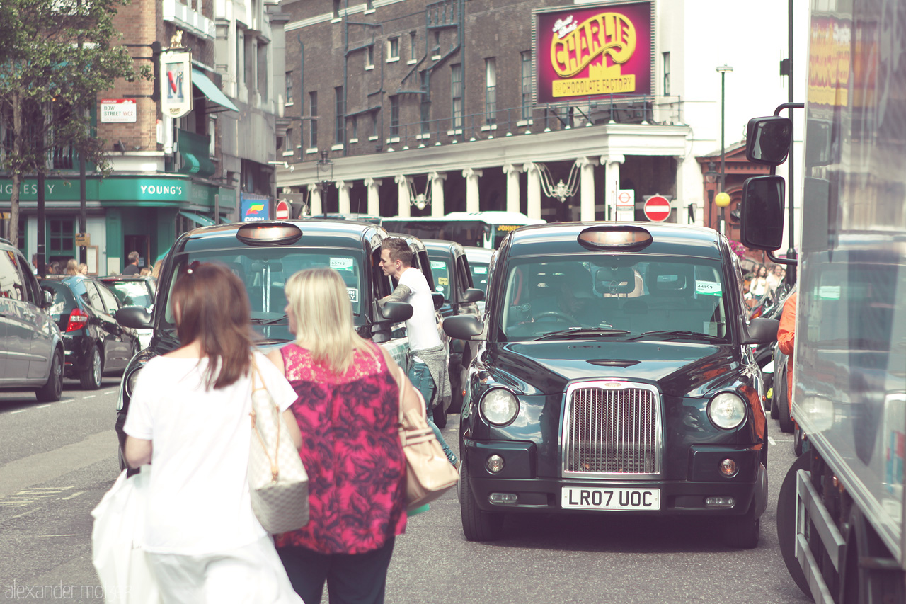 Foto von Black cabs and bustling pedestrians define a lively street scene in Camden, London, encapsulating the city's vibrant urban life.