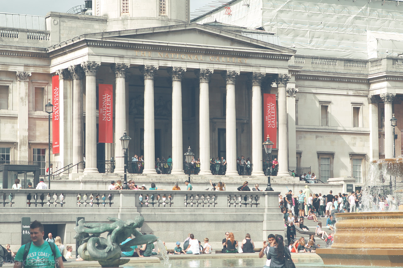 Foto von Crowds gather at Trafalgar Square, soaking in the culture and history of London amidst the iconic columns of the National Gallery.