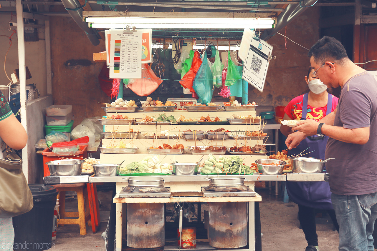 Foto von Discover the vibrant scene of Lok Lok street food in Penang, Malaysia, as locals savor skewered delights from bubbling pots.