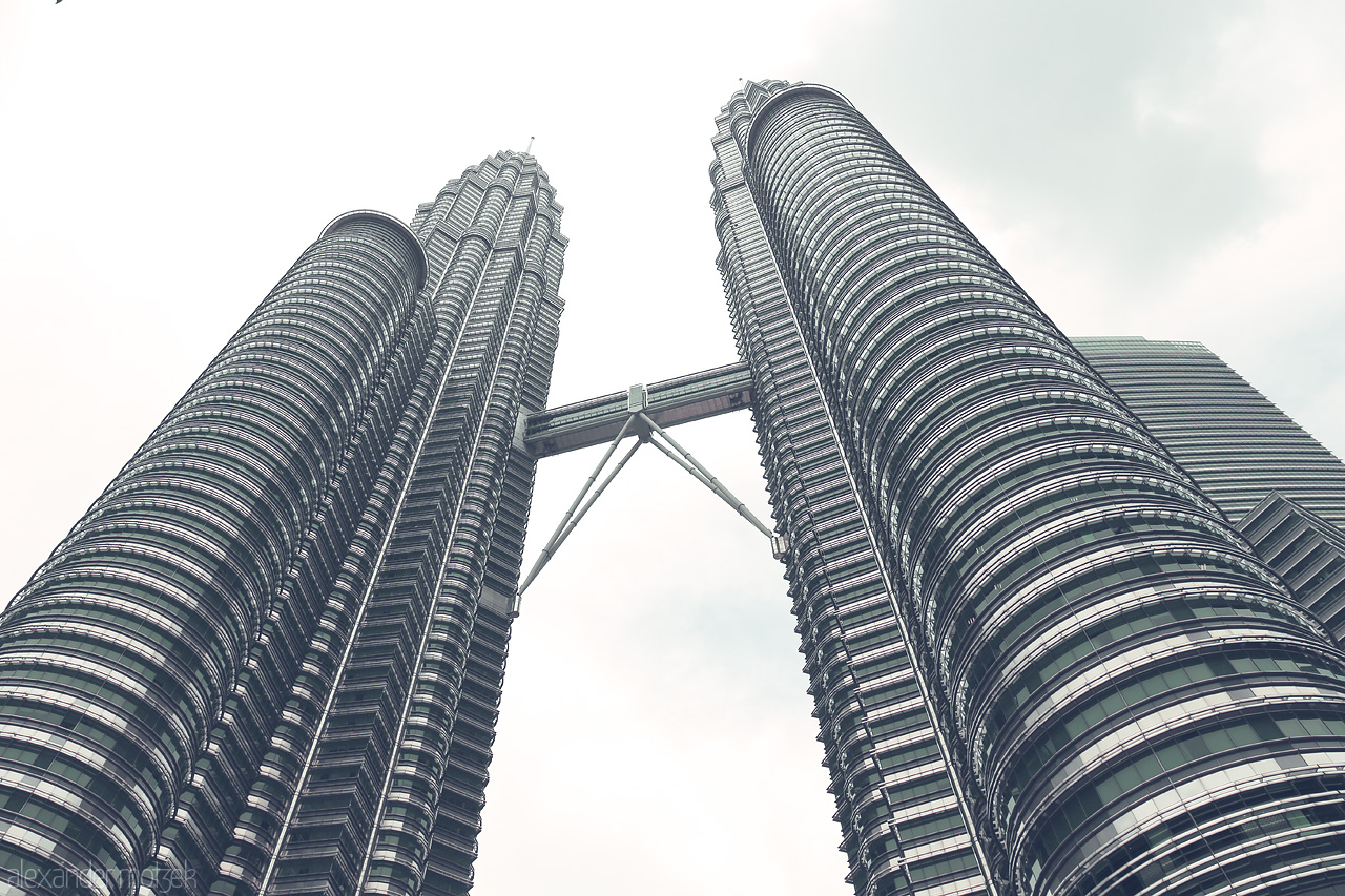 Foto von The iconic Petronas Towers soar into the Kuala Lumpur sky, a symbol of modern Malaysia against a soft, cloudy backdrop.