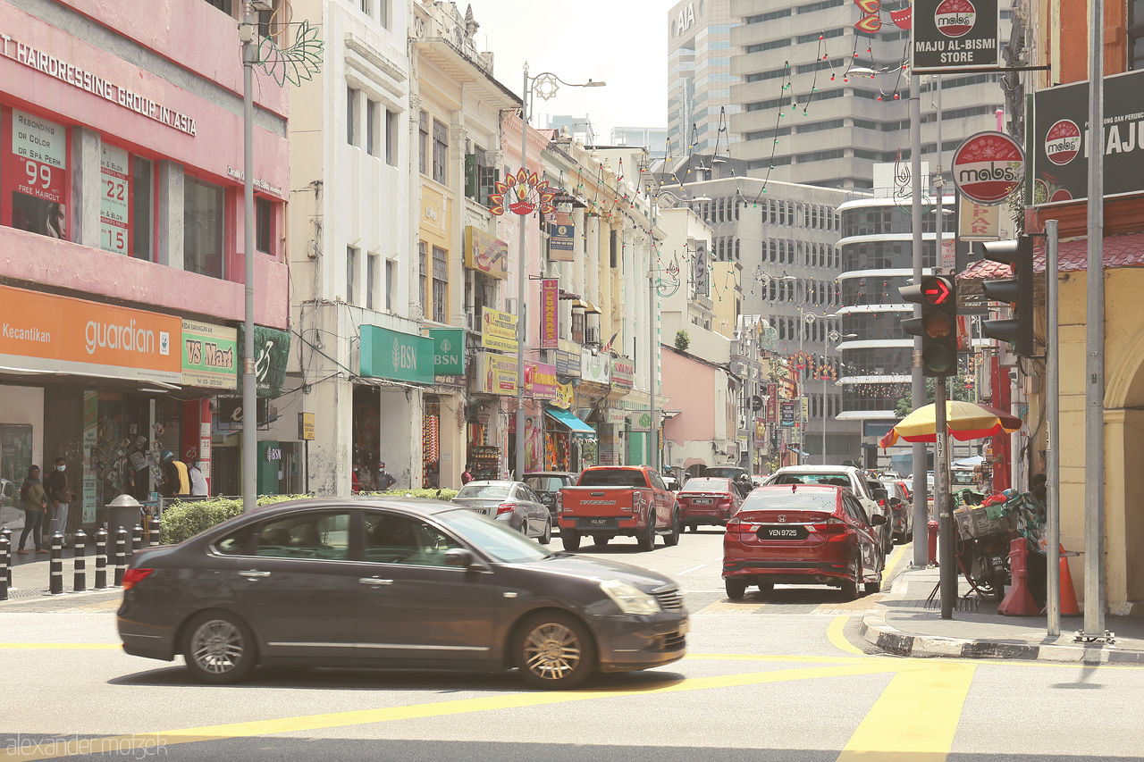 Foto von The vibrant hustle of Kuala Lumpur's streets, blending culture and modernity, with colorful storefronts and bustling traffic.