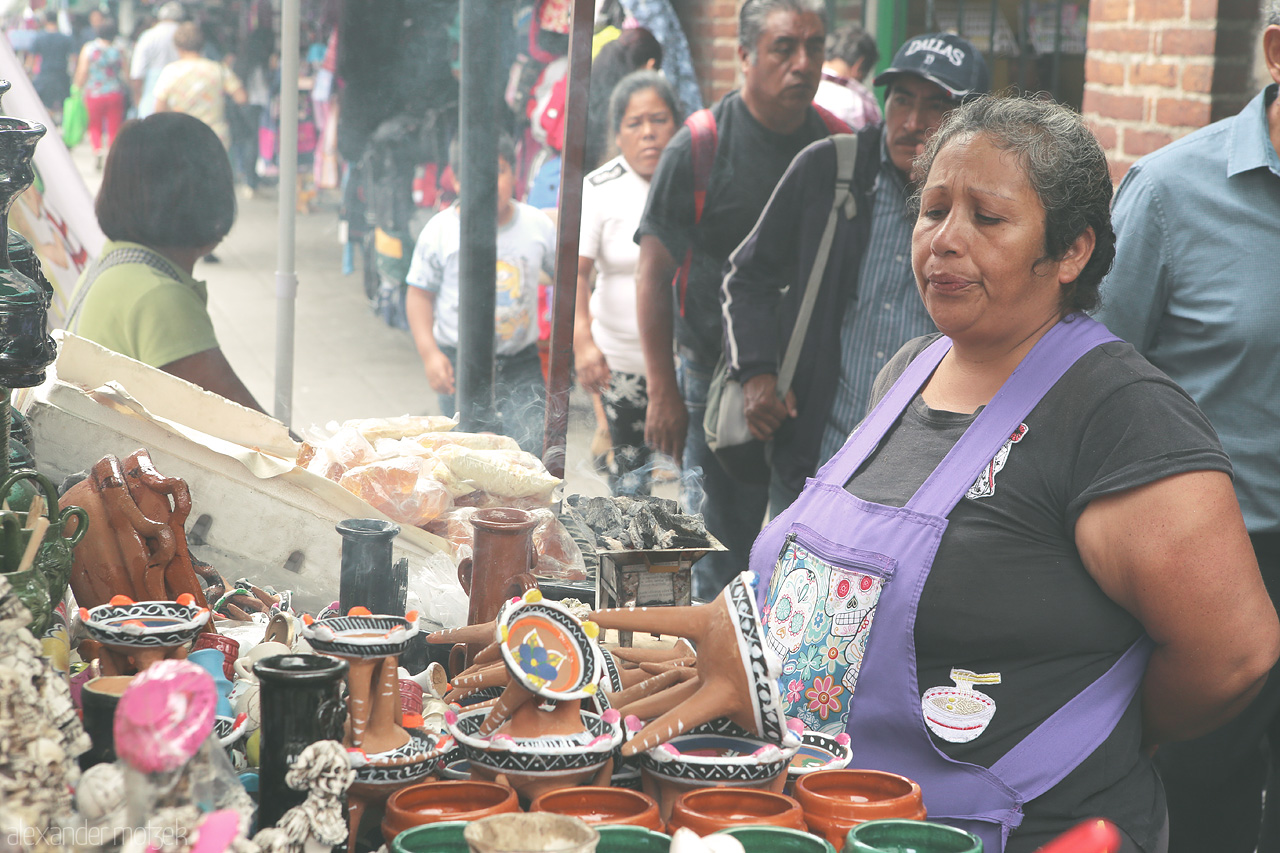Foto von A vendor in Oaxaca de Juárez presents her array of colorful pottery amidst a bustling street scene.