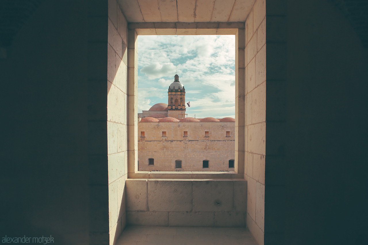 Foto von Framed vista of Oaxaca's historic architecture seen through a stone window, capturing the essence of Mexico.