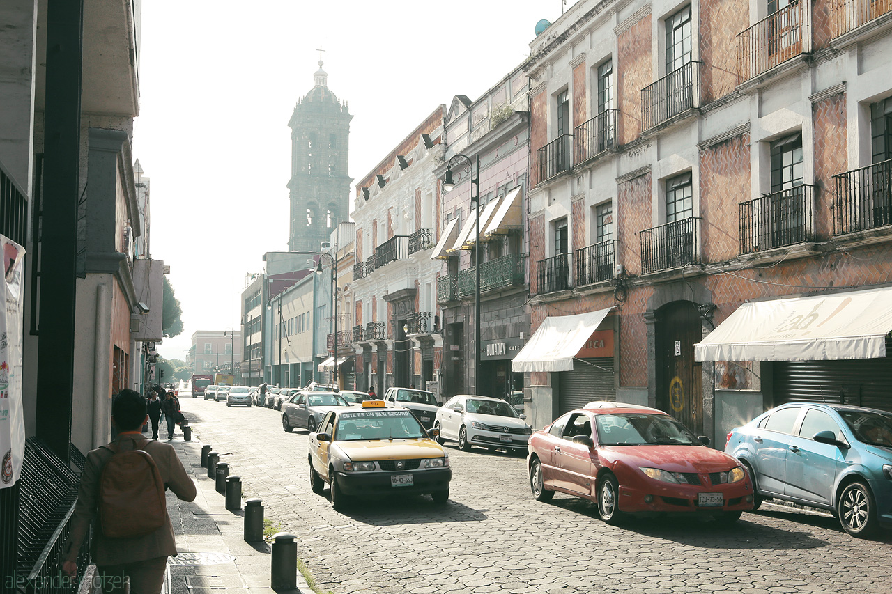Foto von Morning light bathes Puebla's historic streets, colonial architecture aligning a bustling Mexican roadway.