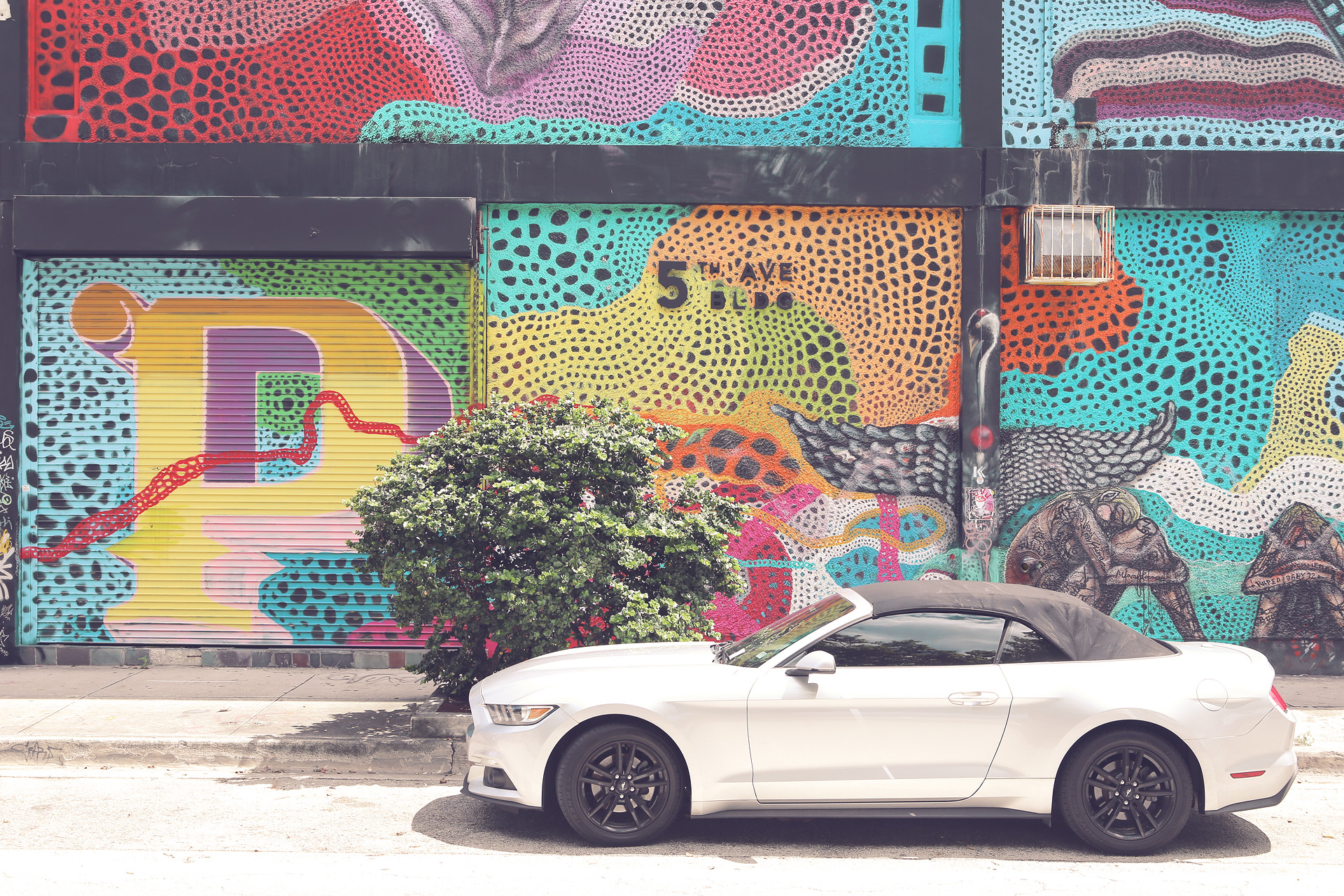 Foto von A contemporary convertible parked against Miami's colorful street art, capturing the city's vibrant and eclectic spirit on 5th Ave.