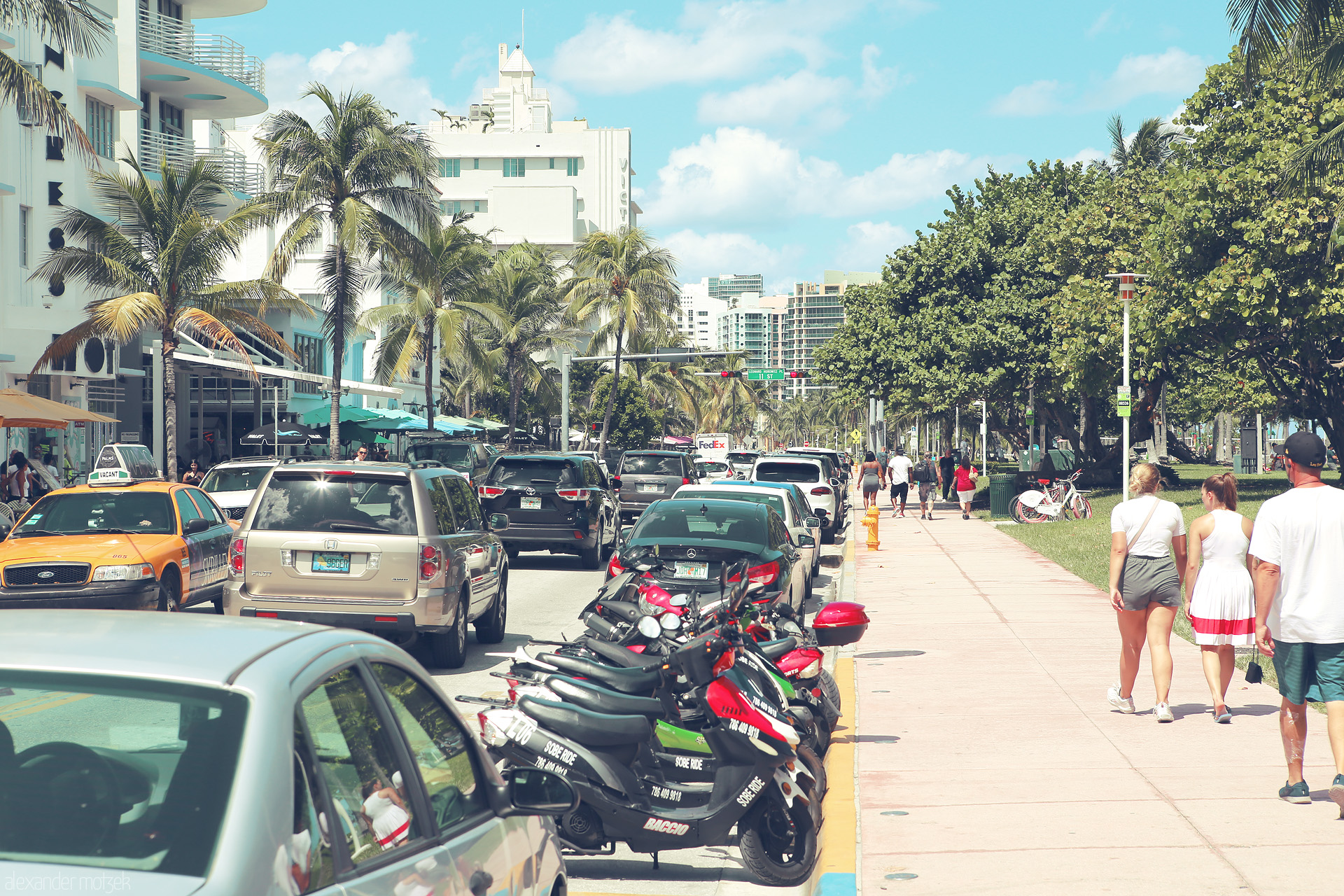 Foto von Breezy palm-lined Ocean Drive hums with life, capturing Miami's vibrant essence and tropical charm on a sunlit day.