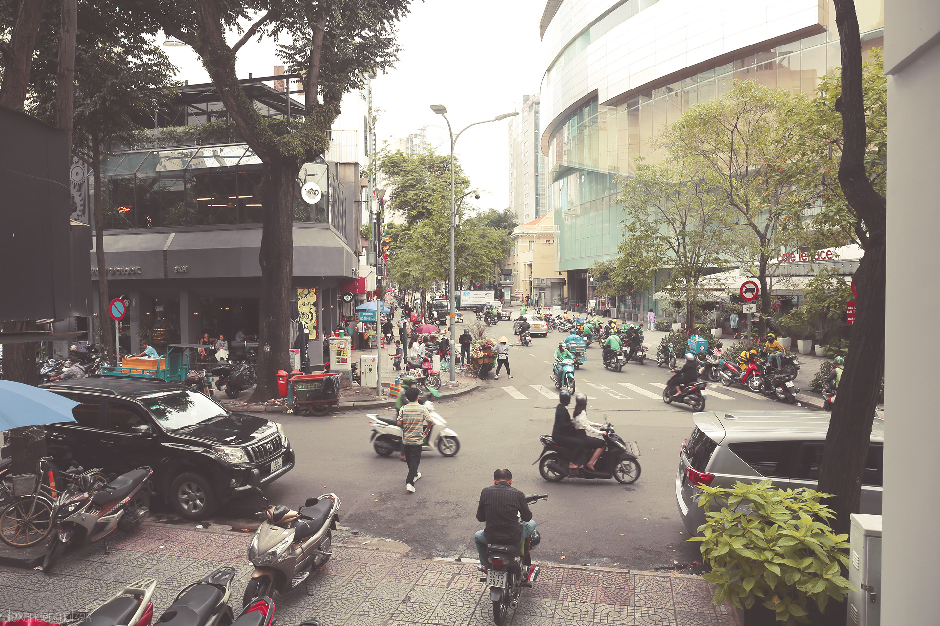 Foto von Morning bustle in central Saigon: scooters, cafés, and city life converge under the urban trees of Ho Chi Minh City.