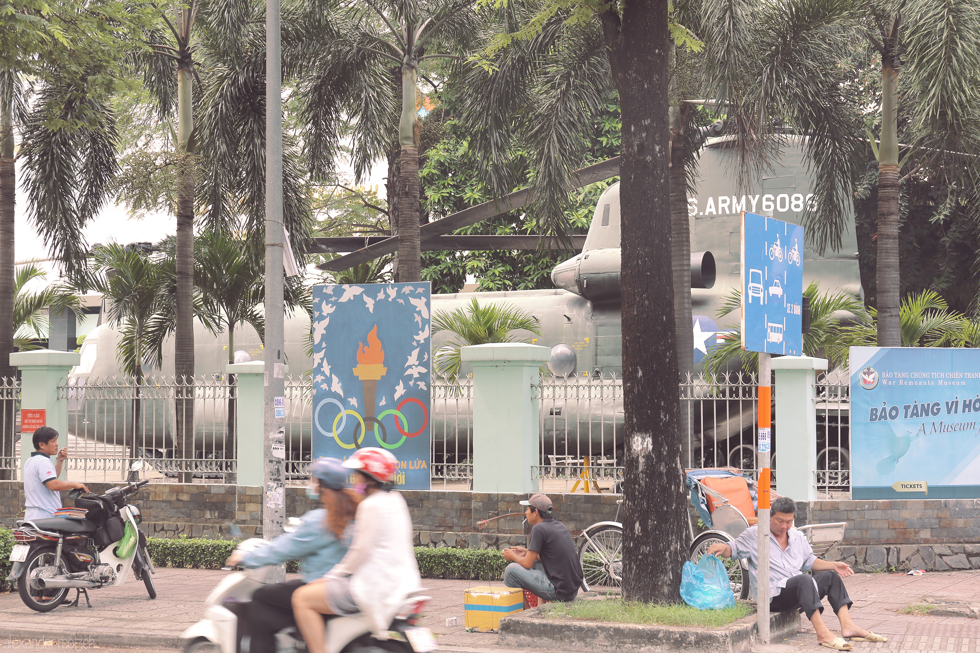 Foto von Motorbikes speed past the War Remnants Museum in Saigon, where echoes of conflict meet the daily pulse of Vietnamese city life.