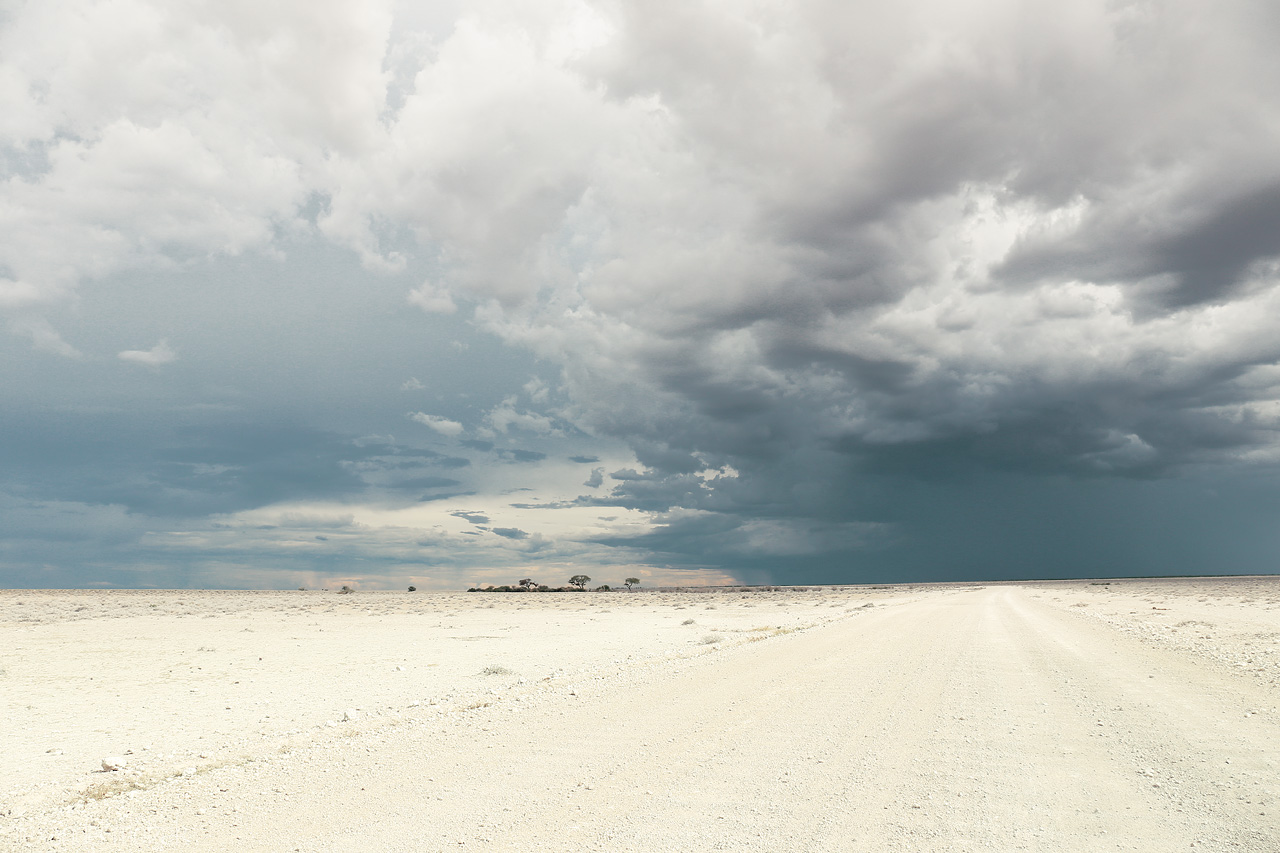 Foto von Vast white Etosha Pan with dramatic storm clouds looming overhead, a quintessential Namibian vista.