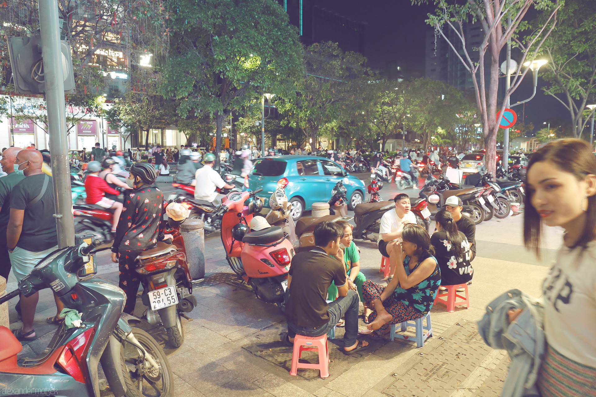 Foto von Nightlife buzz: locals on tiny stools, scooters whir by under Saigon’s trees. A true Ho Chi Minh City street moment.