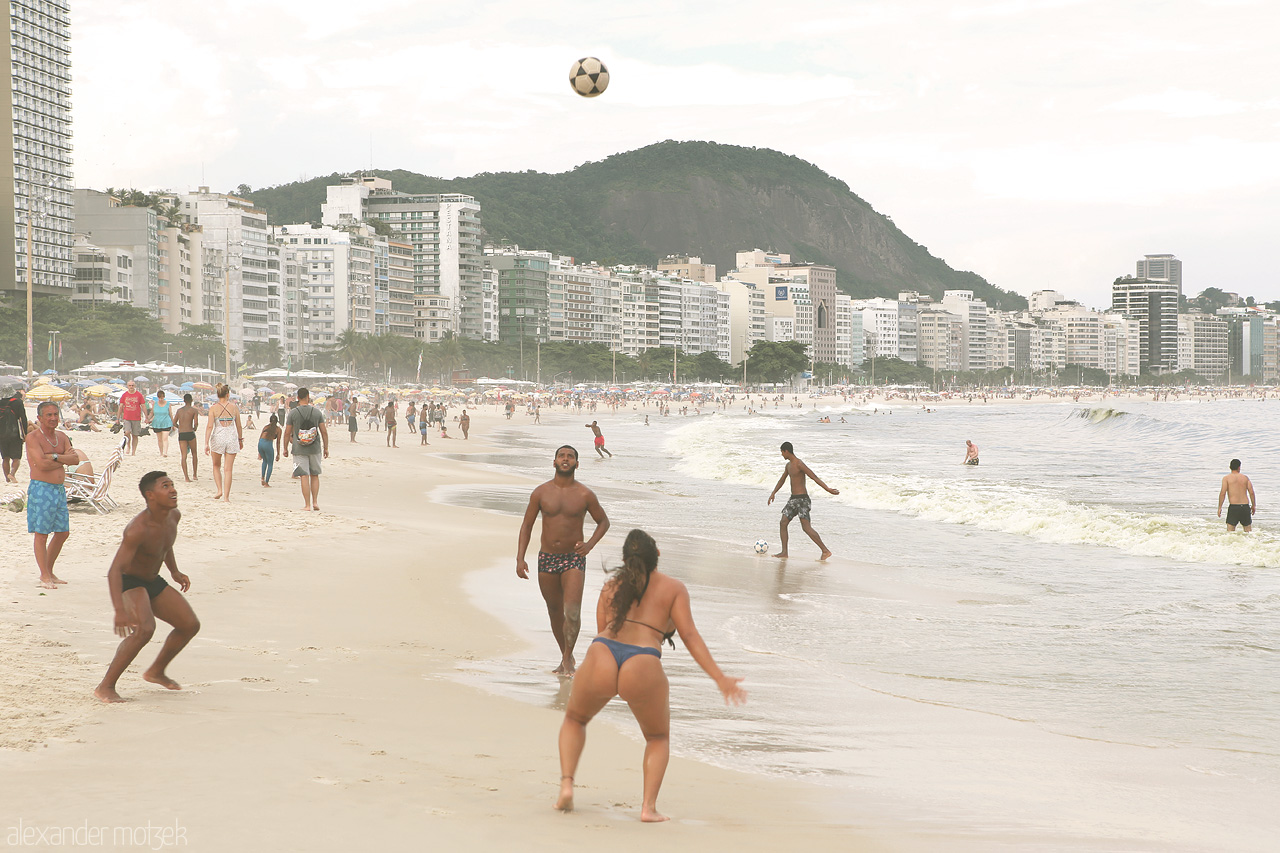 Foto von Vibrant volleyball action amid the iconic Copacabana beach, Rio's urban skyline, and rolling ocean waves.