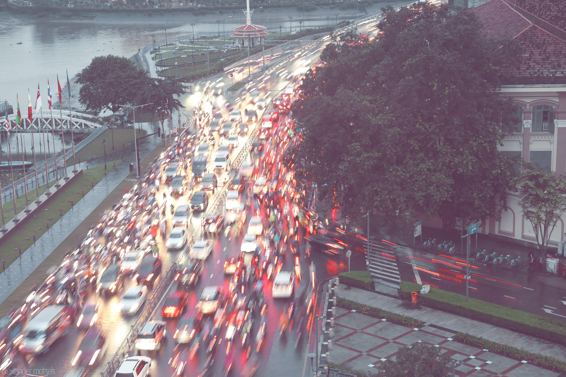 Foto von Rush hour blurs under Saigon rain—vivid lights and motorbikes race beside the river in the heart of Ho Chi Minh City.
