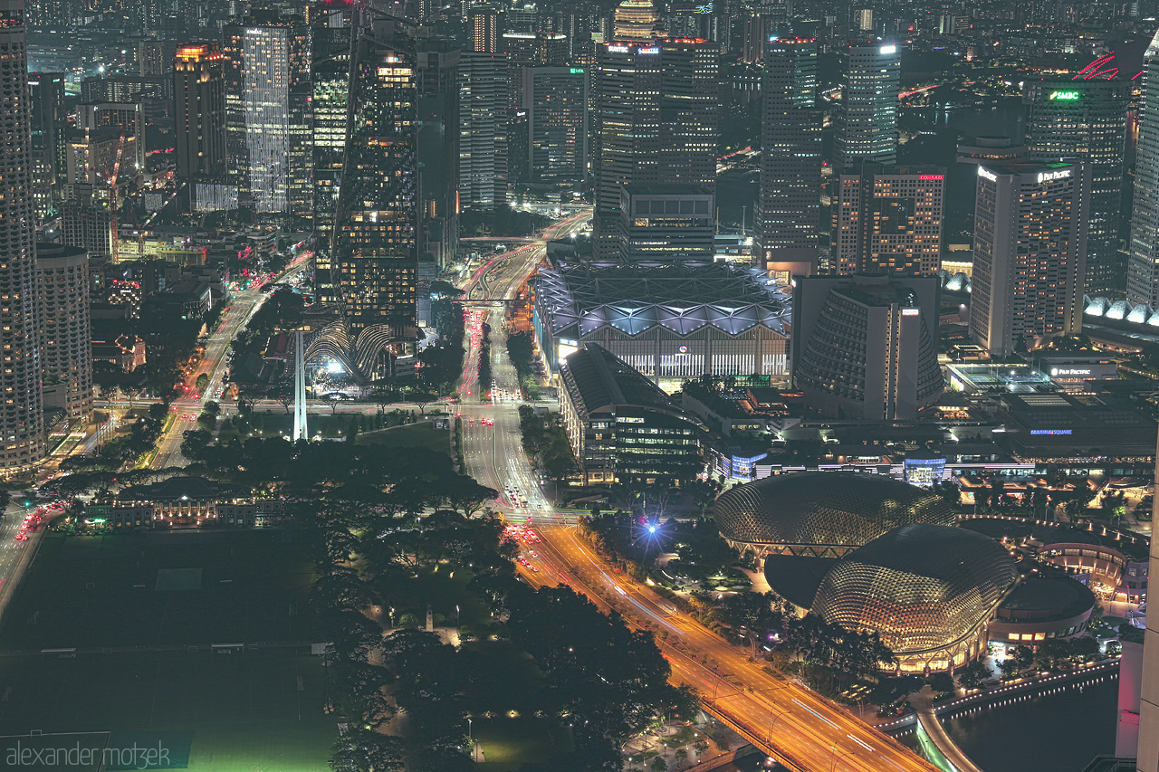 Foto von A stunning nocturnal view over Singapore's skyline, with vibrant lights tracing the city's iconic architecture and bustling roads.