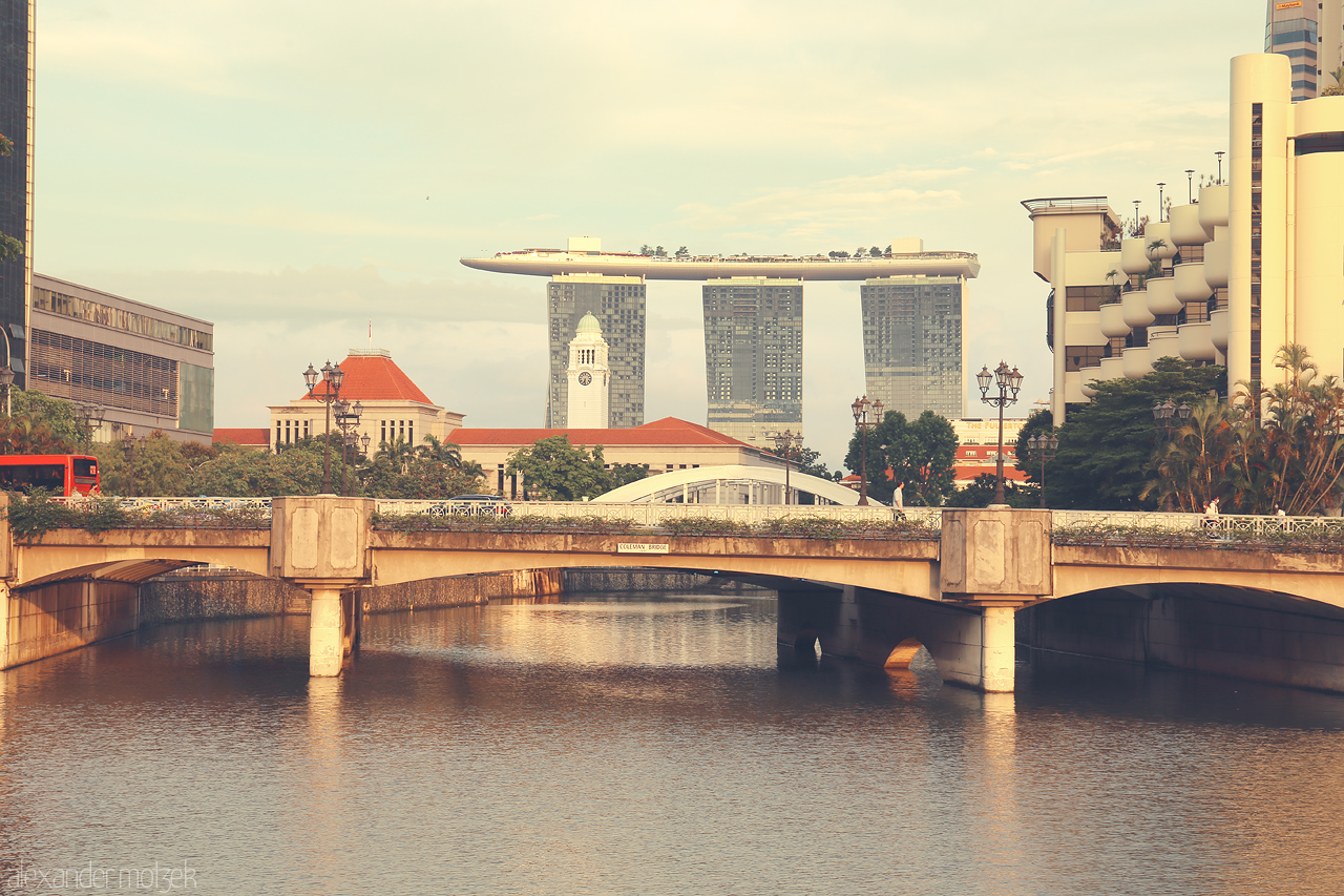 Foto von A tranquil view of Singapore's Marina Bay Sands with the picturesque river and classical bridges in the foreground.