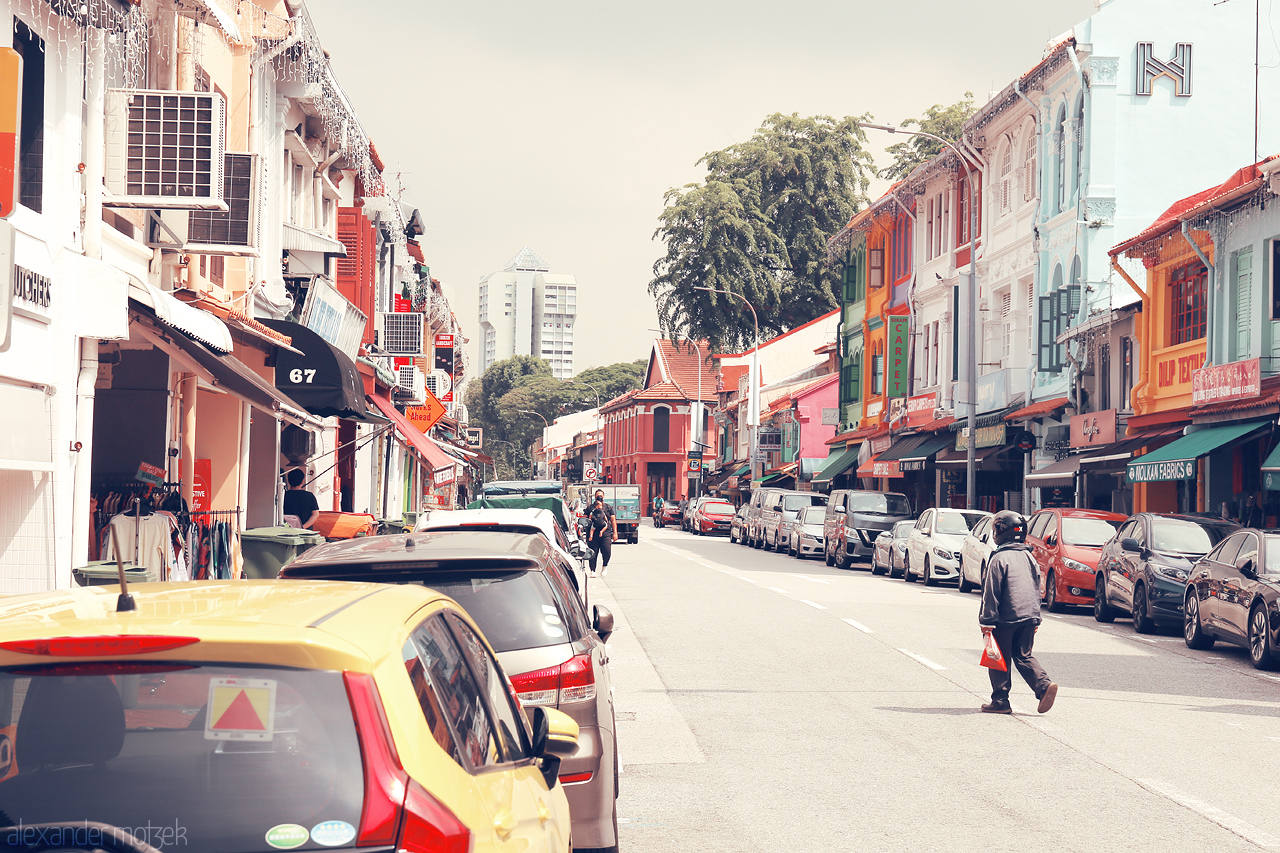 Foto von Bustling Geylang Road in Singapore, showcasing colorful shophouses and vibrant street life on a sunny day.