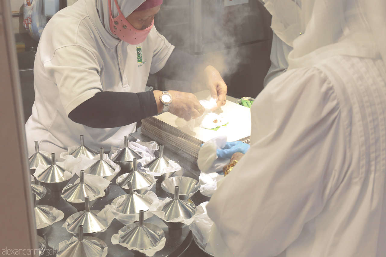 Foto von Crafting Putu Piring in Singapore, a delicate dance of steam, sweet rice flour, and palm sugar, capturing the essence of local tradition.