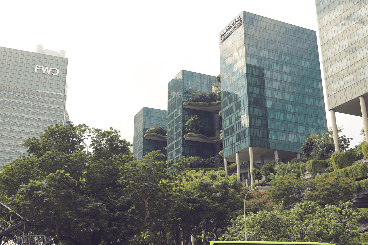 Foto von Modern glass buildings adorned with lush greenery in Singapore, creating a harmonious blend of urban architecture and nature.