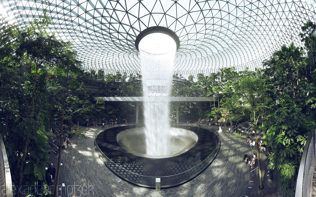 Foto von The majestic waterfall at Jewel Changi Airport, Singapore, cascades within a lush, indoor rainforest.