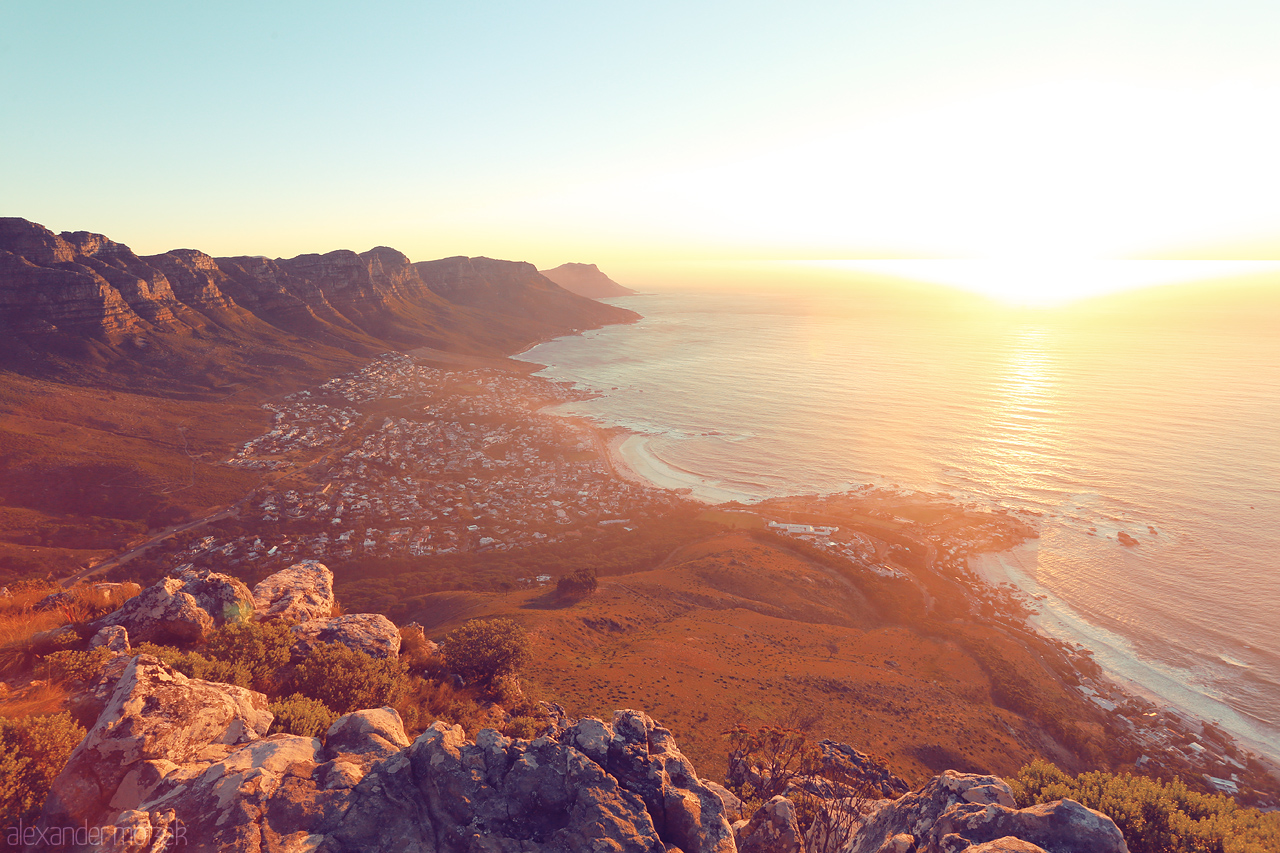 Foto von A breathtaking sunset over Lion's Head, Cape Town, where golden light dances on the ocean and rugged cliffs.