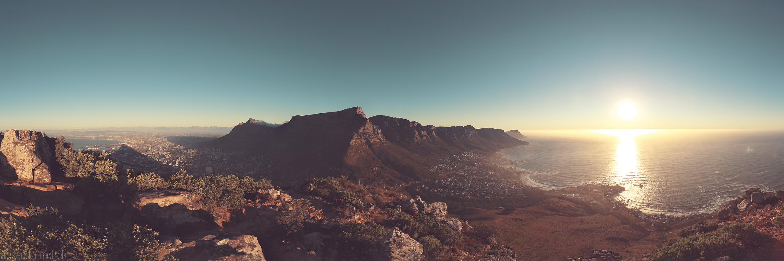 Foto von A breathtaking view from Lion's Head, capturing Cape Town's coastline bathed in the warm hues of sunset. Majestic and serene.