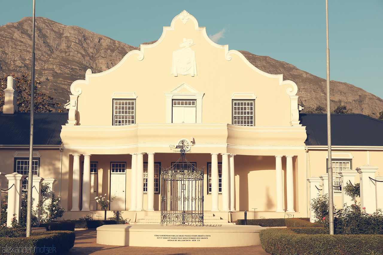 Foto von Elegant Cape Dutch architecture in Franschhoek, with a backdrop of majestic mountains and a tranquil atmosphere.